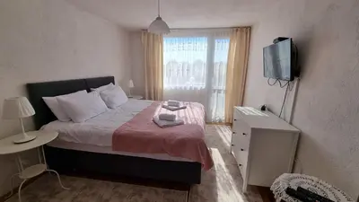a small bedroom with a bed and a television at Къща ВИРА in Yasă-Koriya