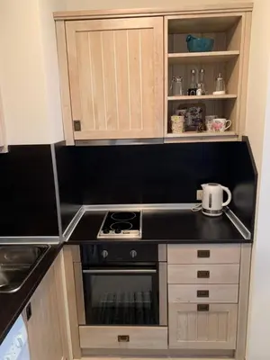 a small kitchen with a stove and cabinets at Private Apartment Pirin Golf Club with Lake View in Razlog
