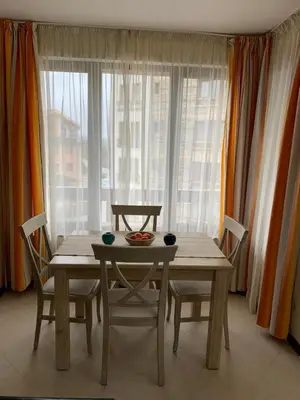 a table and chairs in a room with a window at Private Apartment Pirin Golf Club with Lake View in Razlog