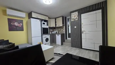 a living room with a kitchen with a refrigerator and a door at Sweet Home 1 in Sandanski