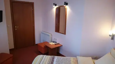 a room with a bed and a table and a mirror at Classic Hotel in Sofia