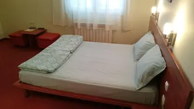 a bed in a hotel room with avertisementatronatronatron at Classic Hotel in Sofia
