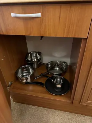 two metal pots and pans in a wooden cabinet at Anna Apartment near Gondola in Bansko