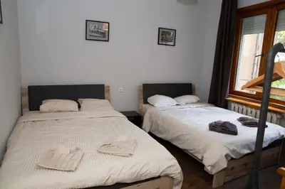 two beds sitting in a room with a window at Central Sofia 3-bedroom apartment - Urban Art gallery - Free Parking! in Sofia