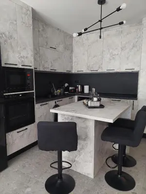 a kitchen with a table and two bar stools at Апартамент Слави in Blagoevgrad