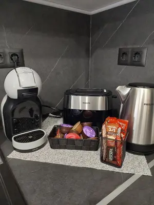 a kitchen counter with a coffee maker and a coffee pot at Апартамент Слави in Blagoevgrad
