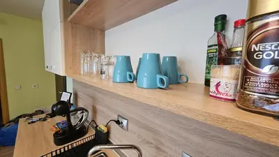 a counter with blue mugs on a wooden shelf at Little City Retreat in Sofia