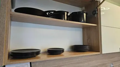 a shelf with black bowls and pans in a kitchen at Little City Retreat in Sofia