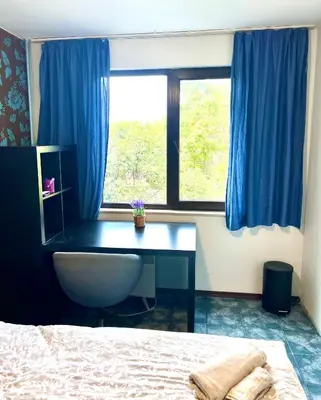 a bedroom with a desk and a bed and a window at The Green Apartment 2BR - free parking in Sofia