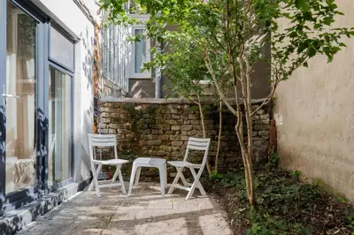 two white chairs and a tree next to a building at 1BD Elegance on Vasil Levski Boulevard by Flat Mаnager in Sofia