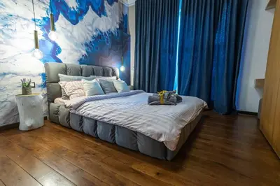 a bedroom with a large bed with blue curtains at Top Central Design, 2 Bedroom, NDK, FREE Secured parking in Sofia