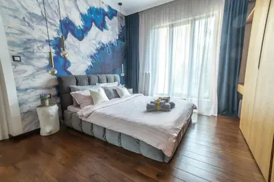 a bedroom with a large bed and a painting on the wall at Top Central Design, 2 Bedroom, NDK, FREE Secured parking in Sofia