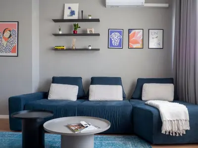 a living room with a blue couch and a table at Central Apartment Parking Two Bedrooms Sky Terrace in Sofia