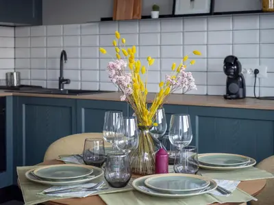 a table with plates and glasses and a vase of flowers at Central Apartment Parking Two Bedrooms Sky Terrace in Sofia