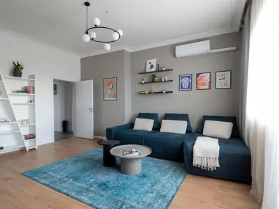 a living room with a blue couch and a table at Central Apartment Parking Two Bedrooms Sky Terrace in Sofia