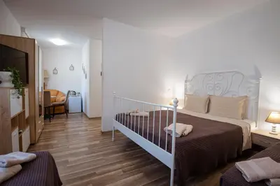 a bedroom with a bed and a living room at Къща за гости ЕМА in Vetren Dol