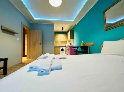 a bedroom with a large white bed with blue walls at Barbie Studio in Sofia