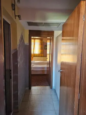 a hallway to a bedroom with a bed and a door at Victori SPA in Dobrinishte