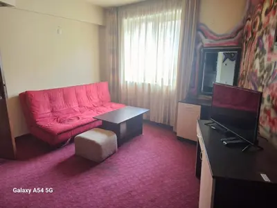 a living room with a red couch and a television at Victori SPA in Dobrinishte