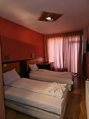a hotel room with two beds and a window at Victori SPA in Dobrinishte