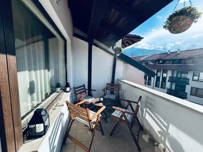 a balcony with two chairs and an umbrella at Bansko Royal Towers Private Apartment V&K in Bansko