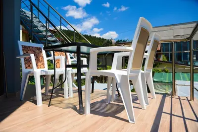a group of white chairs sitting on a balcony at Къща за гости Хаджиеви in Ognyanovo