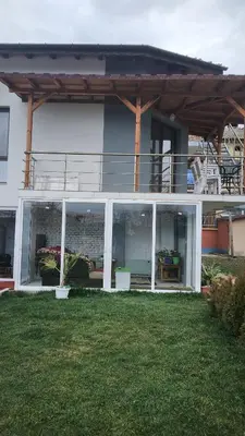 a large white house with a balcony and a yard at Къща за гости Хаджиеви in Ognyanovo
