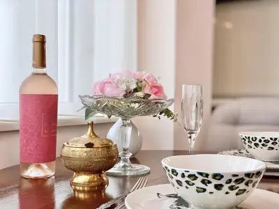 a bottle of wine and a bowl of flowers on a table at Sunny & Cozy Apartment for 4 Guests & Free Parking in Plovdiv