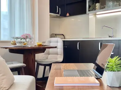 a laptop on a wooden table in a kitchen at Sunny & Cozy Apartment for 4 Guests & Free Parking in Plovdiv
