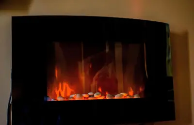 a fire in a fireplace with orange flames at private apartment in a five-star hotel in Bansko in Bansko