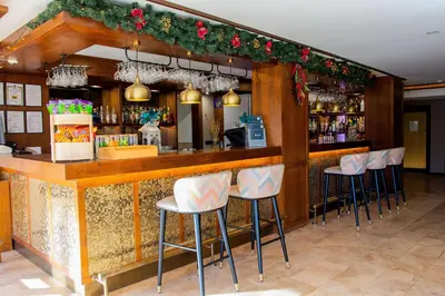 a bar with white stools in a restaurant at private apartment in a five-star hotel in Bansko in Bansko