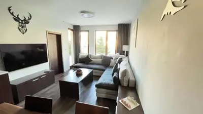 a living room with a couch and a tv at ALTITUDE MOUNTAIN APARTMENTS ASPEN at GONDOLA BANSKO in Bansko