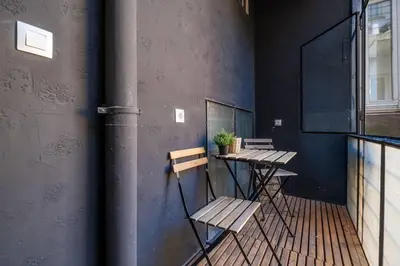 a balcony with two benches and a table with a plant at Stunning Luxury 3 Bedroom Apt in the Heart of Town in Sofia