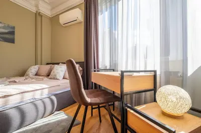 a bedroom with a bed and a desk with a chair at Stunning Luxury 3 Bedroom Apt in the Heart of Town in Sofia