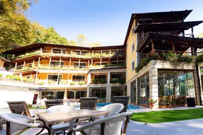 a building with chairs and a table in front of it at Hotel Saint Nedelya in Kolarovo