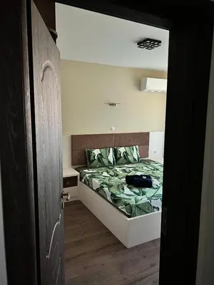 a bedroom with a bed with a green comforter at Ultra Lux Apartment Free Underground Secure Parking in Pazardzhik