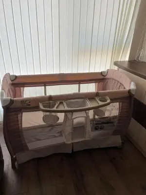 a baby crib with a tray and a baby seat at Ultra Lux Apartment Free Underground Secure Parking in Pazardzhik