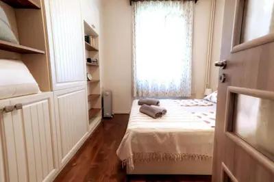 a small bedroom with a bed with a window at Top Center Relax, NDK & Vitoshka str, FREE Secured parking in Sofia