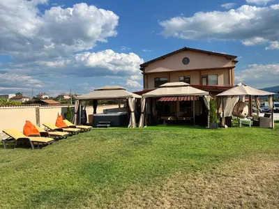 a group of chairs and umbrellas in front of a house at Hani Guest House in Garmen