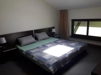 a bedroom with a large bed with a window at Apartament by Zenit in Terra Complex C30 in Razlog