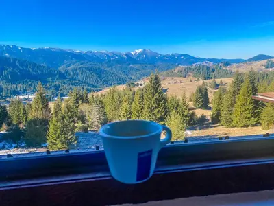 a blue coffee cup sitting on a window sill with a view at Panorama View-Stoykite in Stoykite