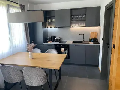 a kitchen with a wooden table and chairs at HillVill in Govedartsi