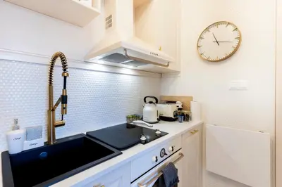 a kitchen with a sink and a clock on the wall at Sofia Royal Retreat in Sofia