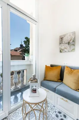 a living room with a couch and a large window at Sofia Royal Retreat in Sofia