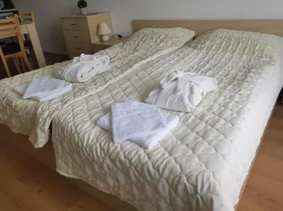 a white bed with towels and towels on it at Фамилно студио Alex&Marry Аспен Резорт Банско in Bansko