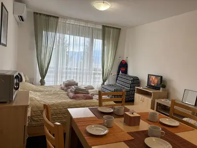 a room with a bed and a table with a dining room at Фамилно студио Alex&Marry Аспен Резорт Банско in Bansko