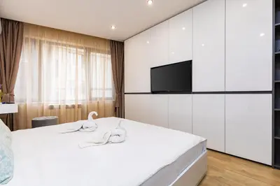 a bedroom with a bed with a flat screen tv at Duos of Delight Matching Urban Apartments for Your Plovdiv Adventure by Flat Mаnager in Plovdiv