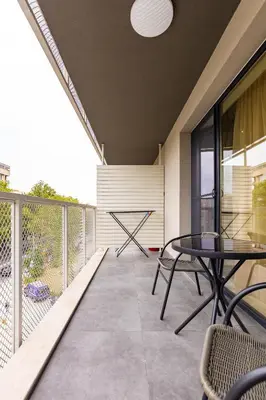 a patio with a table and chairs on a balcony at Duos of Delight Matching Urban Apartments for Your Plovdiv Adventure by Flat Mаnager in Plovdiv