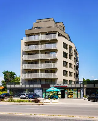 a tall building with cars parked in front of it at Duos of Delight Matching Urban Apartments for Your Plovdiv Adventure by Flat Mаnager in Plovdiv