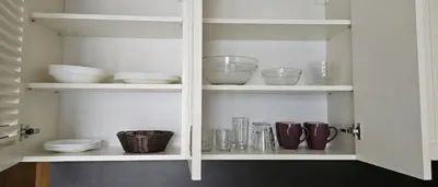a white cabinet with dishes and bowls and plates at Four Seasons Apartment Bansko in Bansko